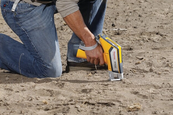 Researcher using Niton XRF Analyzer for soil analysis