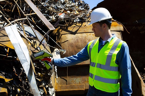 Scrap metal yard worker using Niton XRF analyzer in the field
